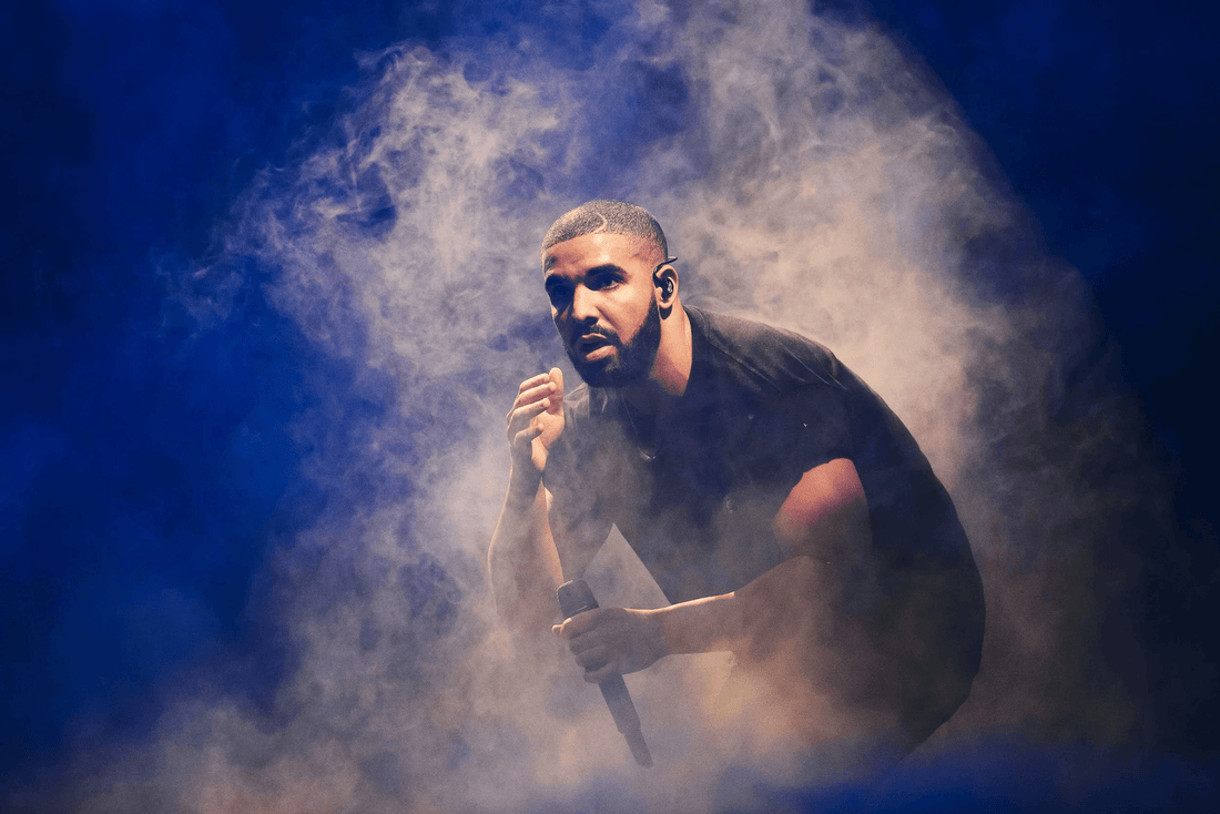 drake in the midst of smoke holding a microphone